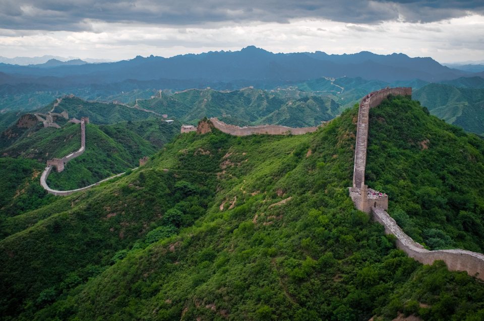 A winding section of the Great Wall of China stretching across mountains.