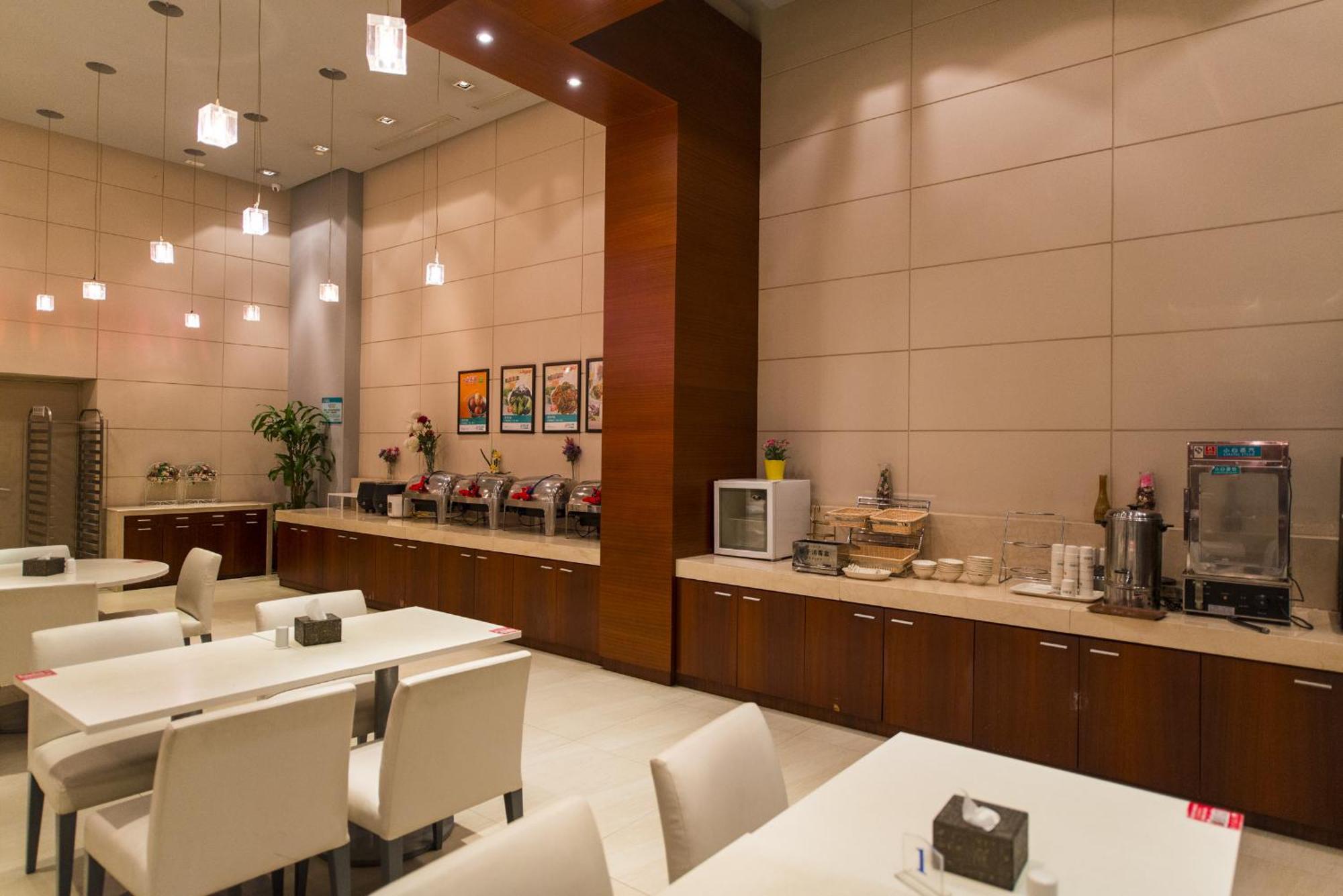 The entrance and lobby area of a Jinjiang Inn Style hotel, featuring a simple, modern design.