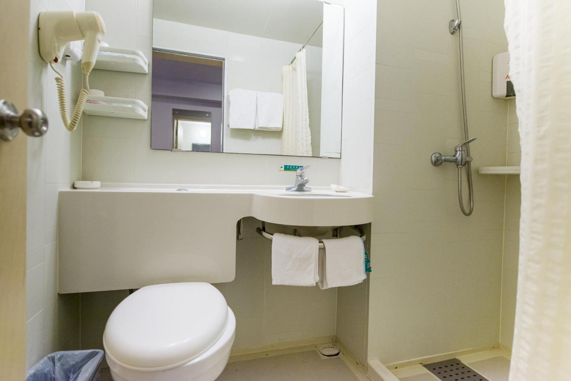 A simple yet comfortable hotel room with two single beds, ideal for friends or family.