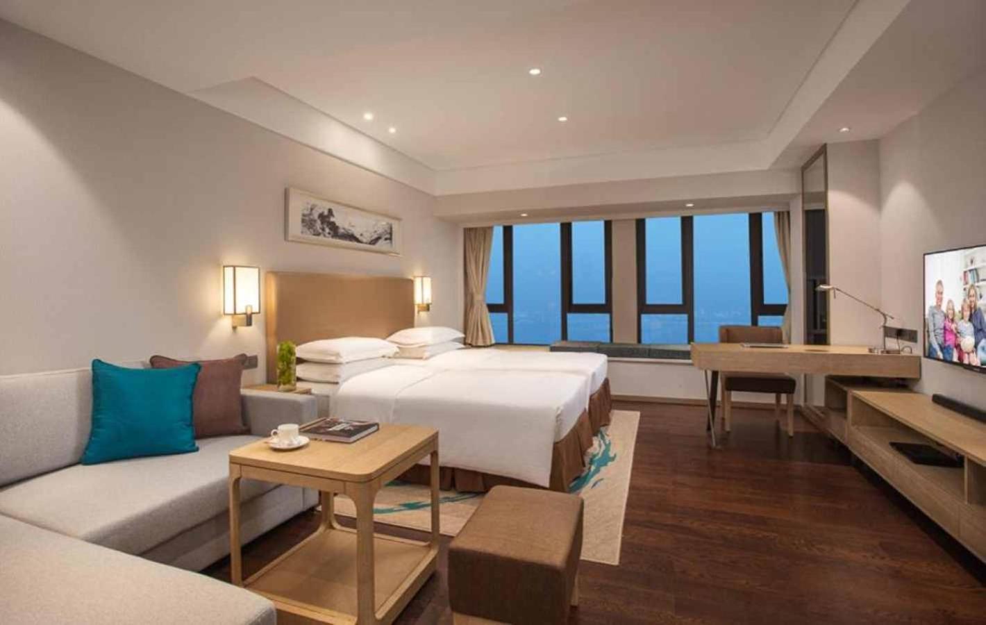 A spacious living room in an apartment, with modern furniture and a flat-screen TV.