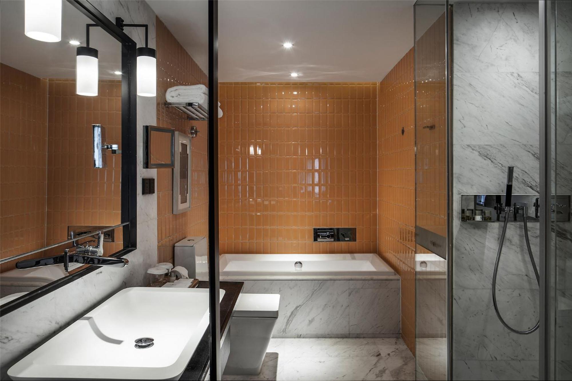 A hotel room with a comfortable bed, a small desk, and a modern aesthetic.